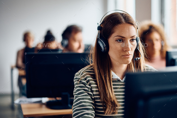 Woman with headset using desktop PC while attending computer class